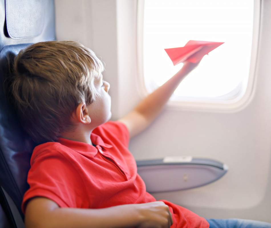 Young Boy On-board With Red Paper Airplane